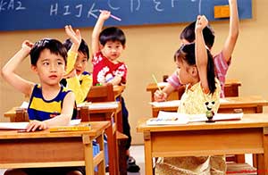 兒童在課堂上舉手回答老師的問(wèn)題